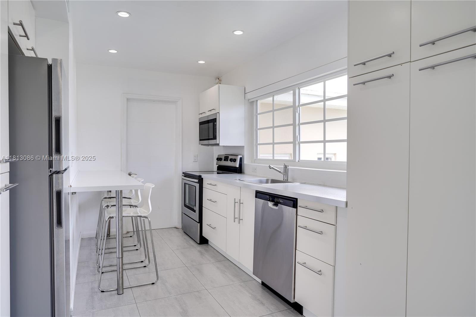 1201 South Biscayne Point Road Miami Beach, FL 33141 - Photo 13 of 35 a kitchen with white cabinets and stainless steel appliances
