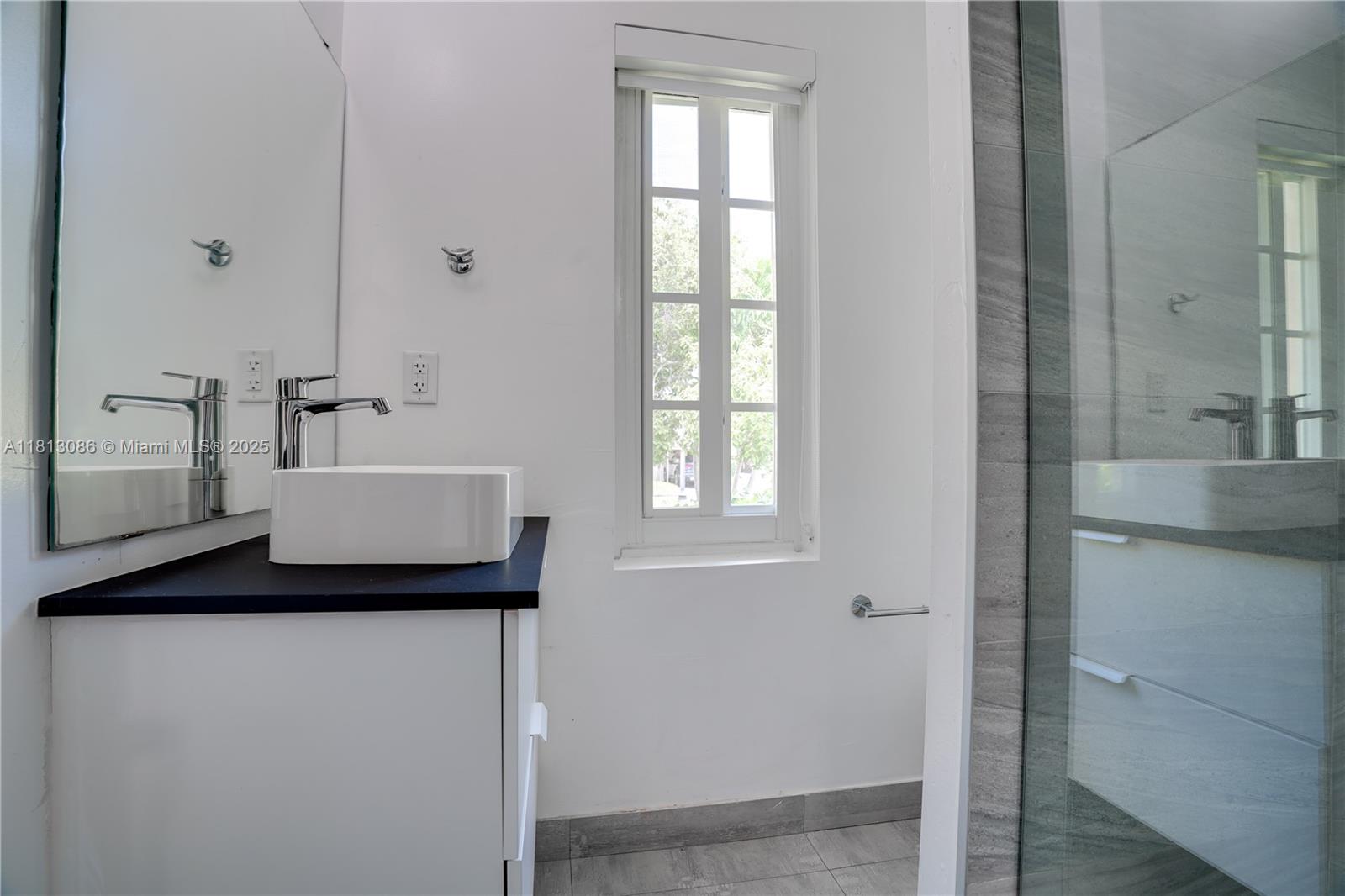 1201 South Biscayne Point Road Miami Beach, FL 33141 - Photo 17 of 35 a bath room with a sink and a mirror