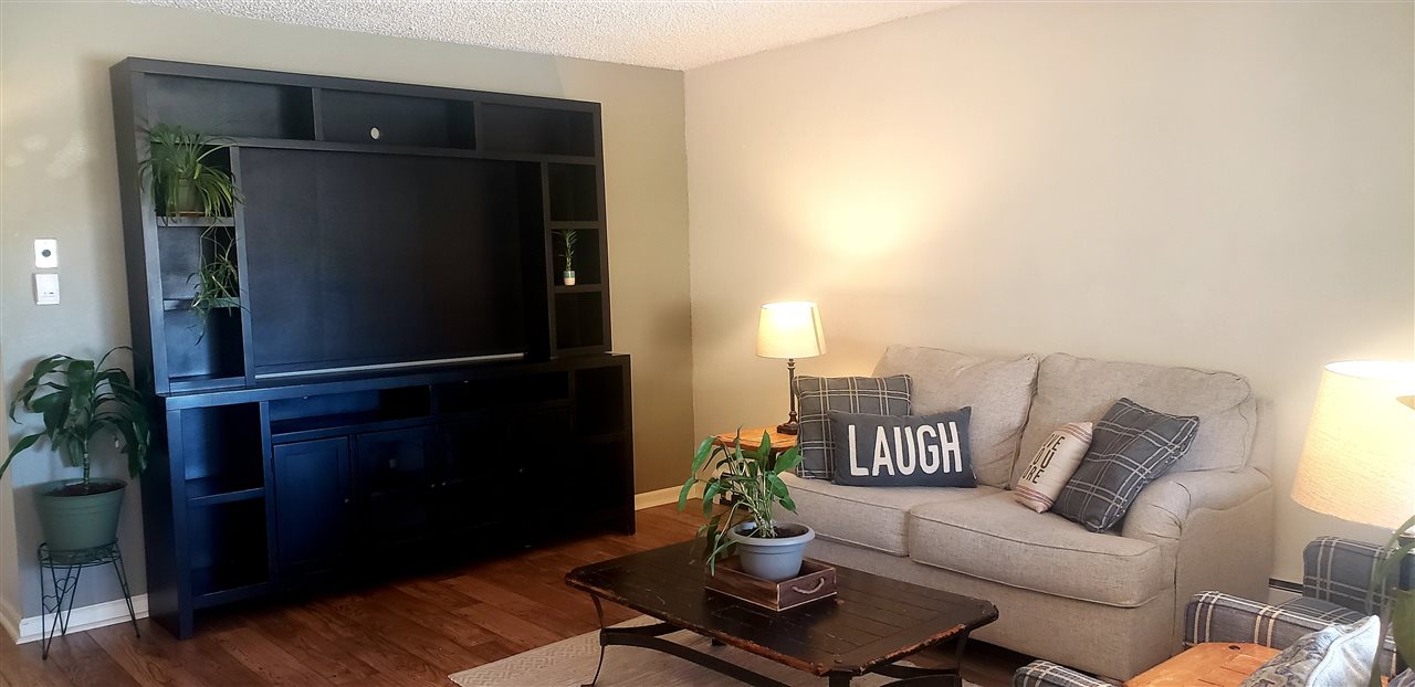 406 Ridges Boulevard, Unit 18 Grand Junction, CO 81507 - Photo 3 of 25 a living room with furniture and a lamp