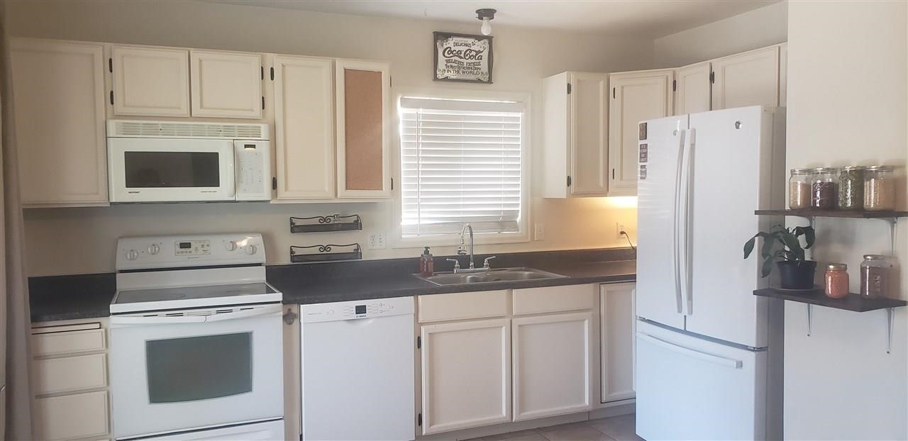 406 Ridges Boulevard, Unit 18 Grand Junction, CO 81507 - Photo 10 of 25 a kitchen with white cabinets and white appliances