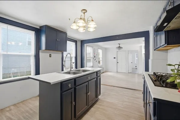 a large kitchen with kitchen island a sink stainless steel appliances and cabinets