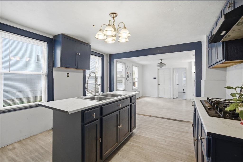 53 Fremont Street, Unit 1 Springfield, MA 01105 - Photo 2 of 9 a large kitchen with kitchen island a sink stainless steel appliances and cabinets