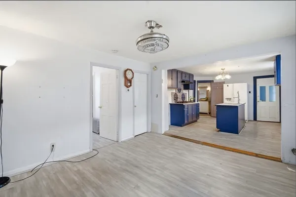 a view of a kitchen with a fridge and wooden floor