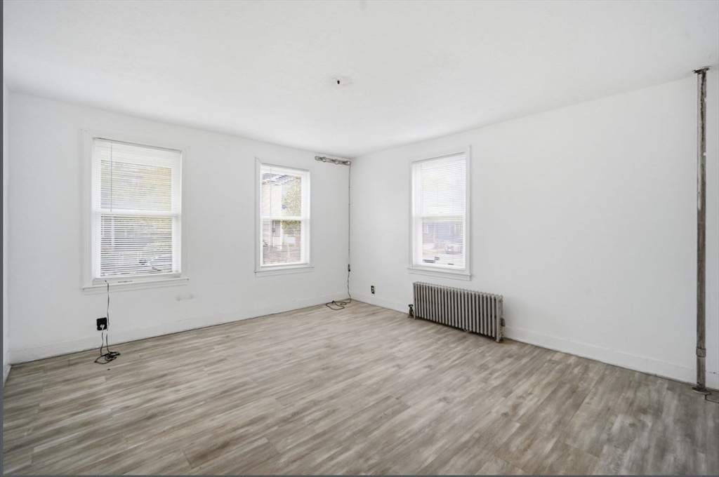 53 Fremont Street, Unit 1 Springfield, MA 01105 - Photo 6 of 9 an empty room with wooden floor and windows