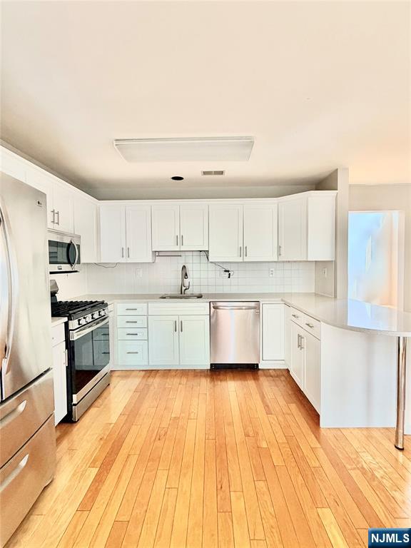 35 Harrier Court, Unit 35 Wayne, NJ 07470 - Photo 7 of 16 a large kitchen with stainless steel appliances and white cabinets