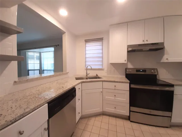 a kitchen with granite countertop white cabinets and white appliances