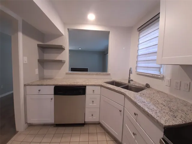 a kitchen with granite countertop white cabinets and white appliances