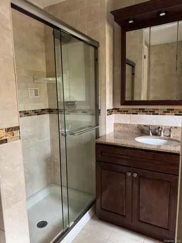 a bathroom with a shower sink and mirror