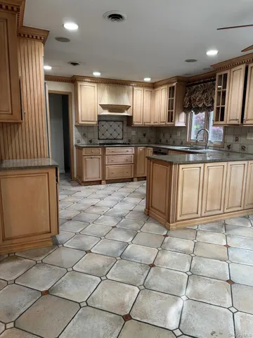 a kitchen with stainless steel appliances kitchen island granite countertop a sink and cabinets