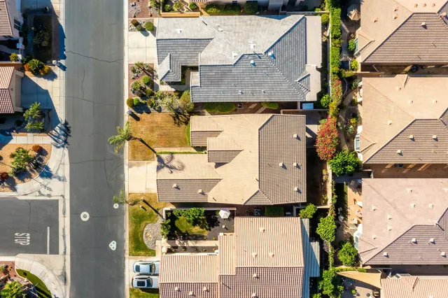 an aerial view of residential houses with outdoor space and parking