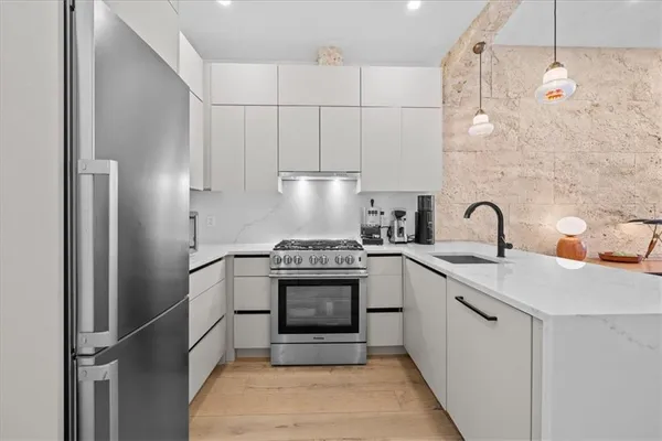 a kitchen with cabinets a sink and stainless steel appliances