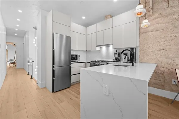 a kitchen with a sink a refrigerator and cabinets