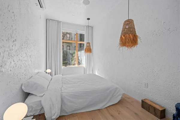 a bedroom with a bed and a window