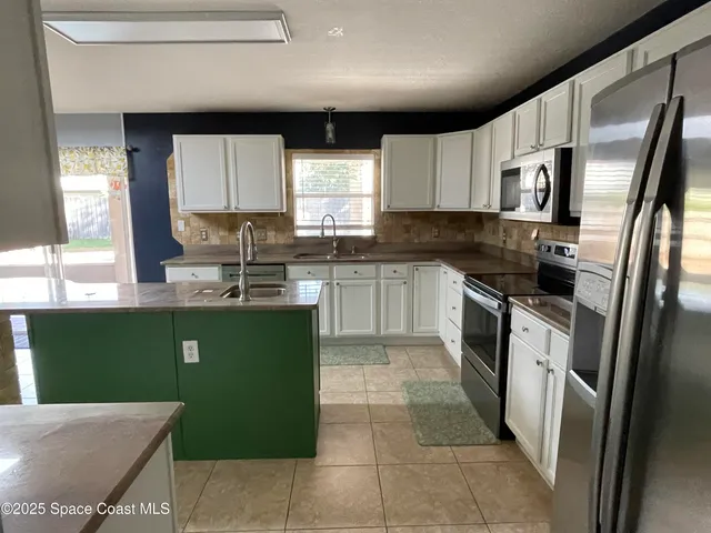 a kitchen with a sink cabinets and stainless steel appliances