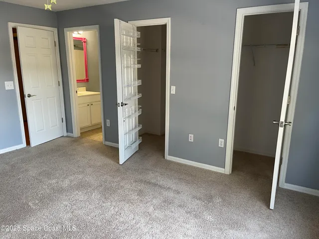 an empty room with closet and a bathroom view