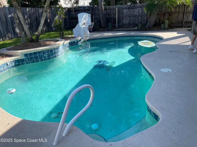 a swimming pool with some trees in the background