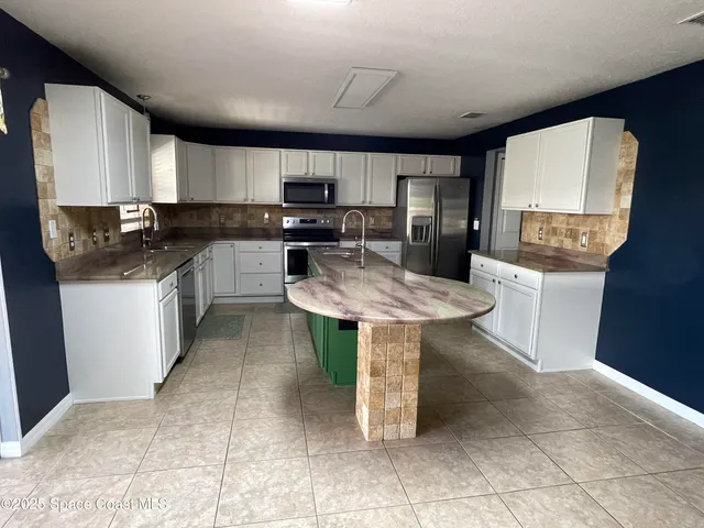 a kitchen with a sink a counter top space and appliances