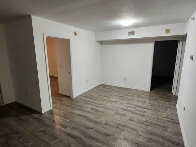 an empty room with wooden floor and closet