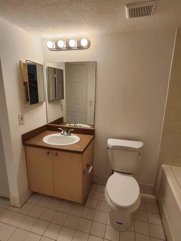 a bathroom with a sink toilet and mirror