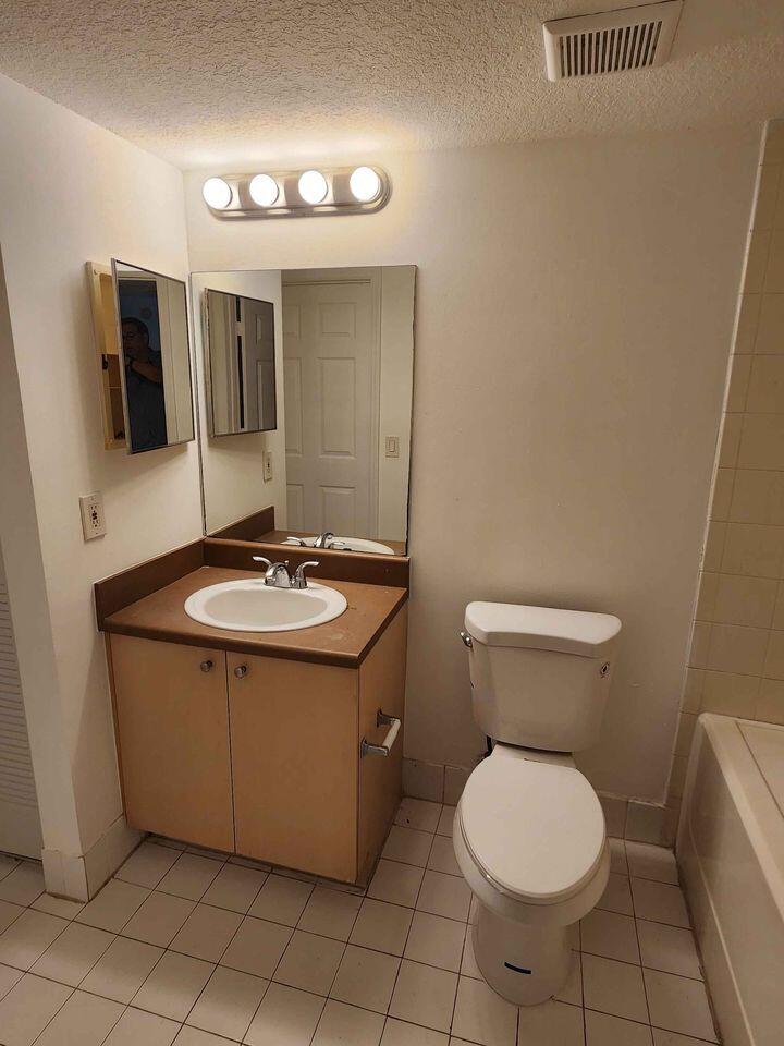 4081 San Marino Boulevard, Unit 203 West Palm Beach, FL 33409 - Photo 7 of 9 a bathroom with a sink toilet and mirror