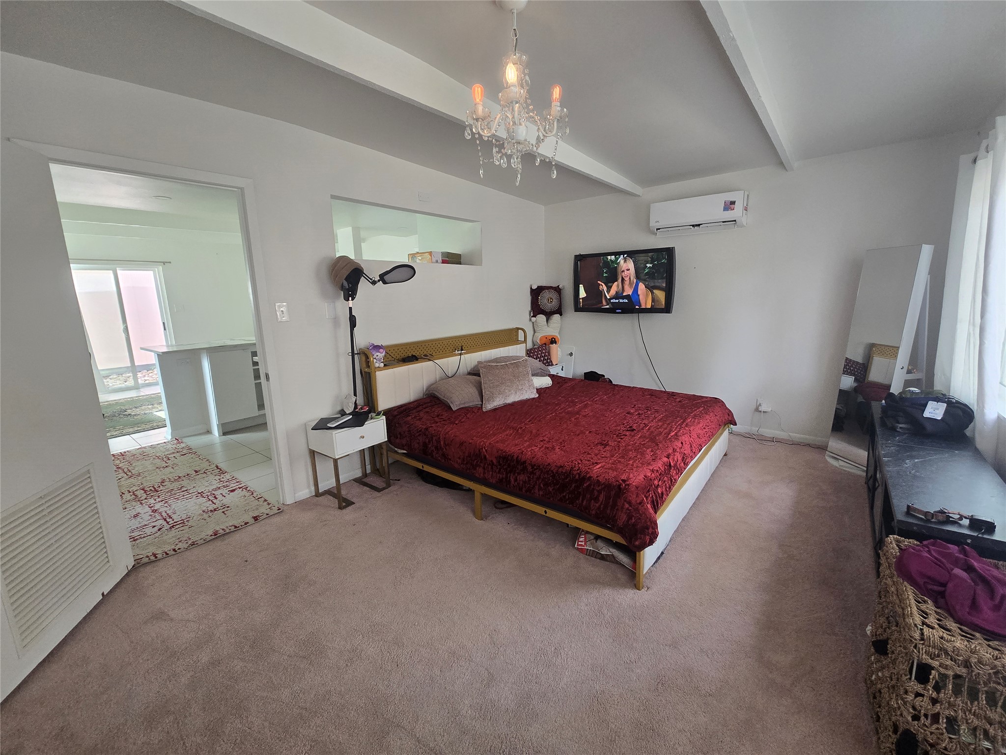 1106 The High Road, Unit A Austin, TX 78746 - Photo 4 of 12 Carpeted bedroom with beamed ceiling, suspended lighting, and a wall mounted mini split