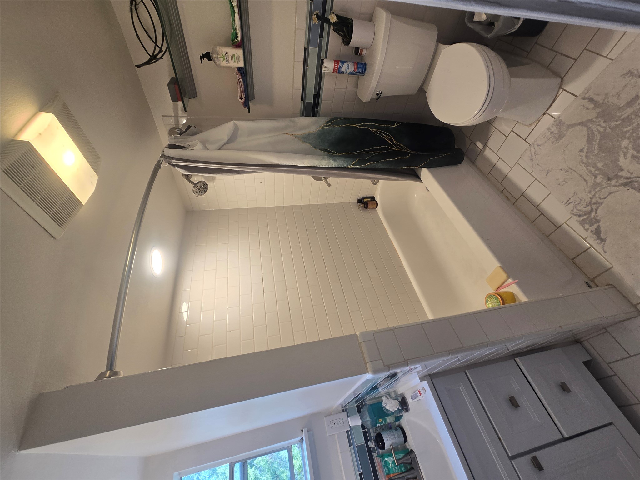 1106 The High Road, Unit A Austin, TX 78746 - Photo 7 of 12 Full bath featuring tile walls, shower / tub combo with curtain, vanity, and wainscoting