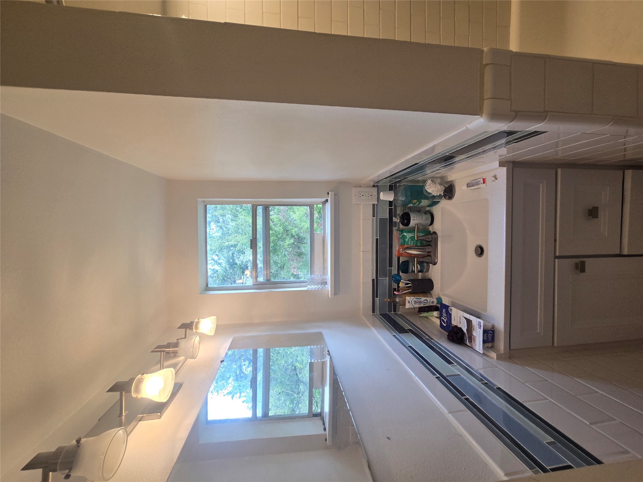 1106 The High Road, Unit A Austin, TX 78746 - Photo 8 of 12 Bathroom with vanity, wainscoting, and a shower