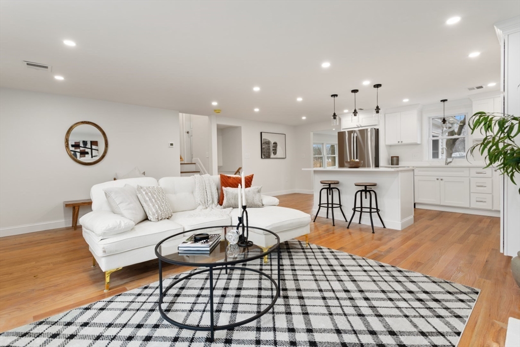 83 Riverbank Road Saugus, MA 01906 - Photo 11 of 36 a living room with furniture a clock on wall and a table