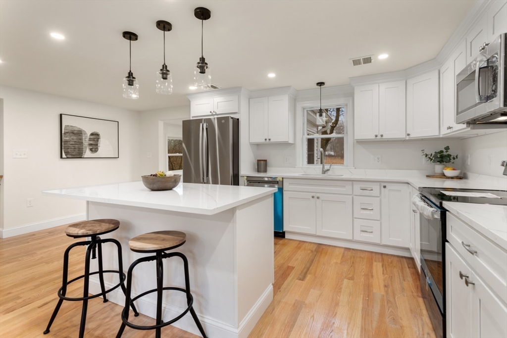 83 Riverbank Road Saugus, MA 01906 - Photo 14 of 36 a kitchen with a table chairs refrigerator and cabinets