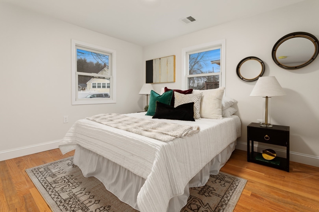 83 Riverbank Road Saugus, MA 01906 - Photo 22 of 36 a bedroom with a bed and a lamp on dresser