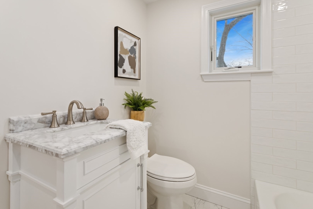 83 Riverbank Road Saugus, MA 01906 - Photo 28 of 36 a bathroom with a granite countertop sink and a toilet