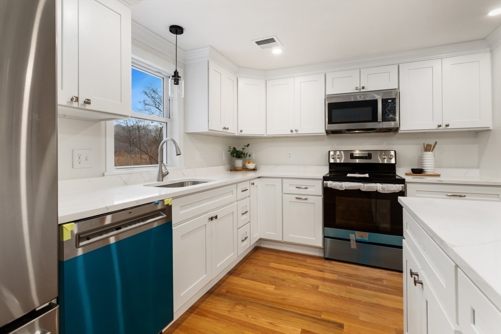 83 Riverbank Road Saugus, MA 01906 - Photo 3 of 36 a kitchen with stainless steel appliances granite countertop a stove a sink and a refrigerator