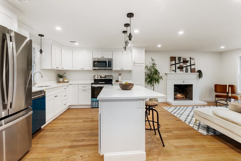 83 Riverbank Road Saugus, MA 01906 - Photo 4 of 36 a kitchen with a stove a refrigerator and a fireplace