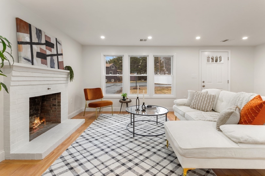 83 Riverbank Road Saugus, MA 01906 - Photo 10 of 36 a living room with furniture and a fireplace