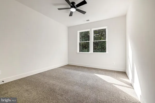 an empty room with a empty space and a ceiling fan