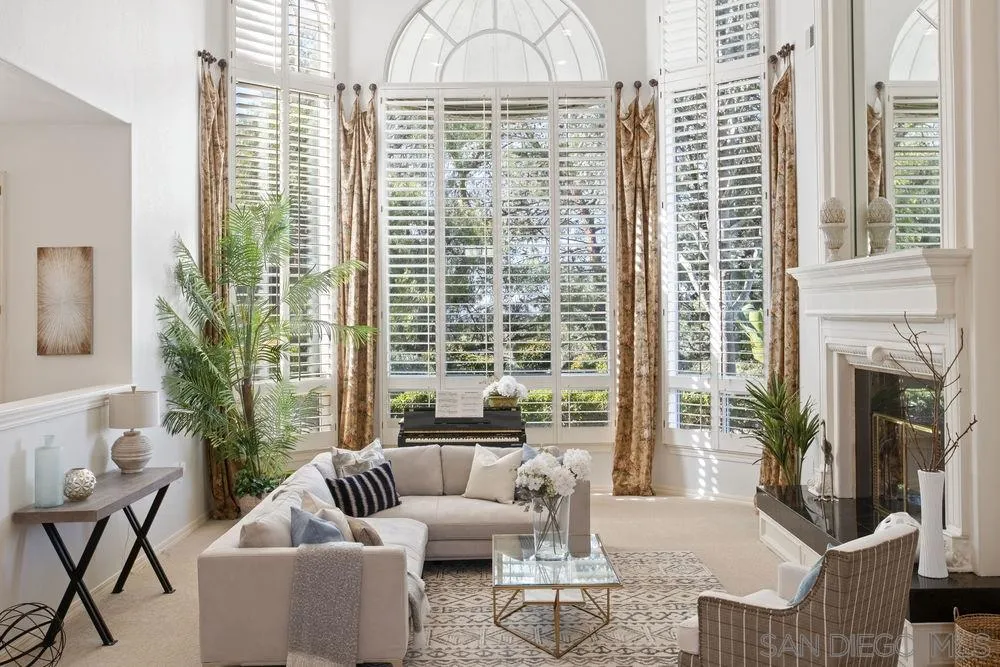 a living room with furniture a large window and a fireplace