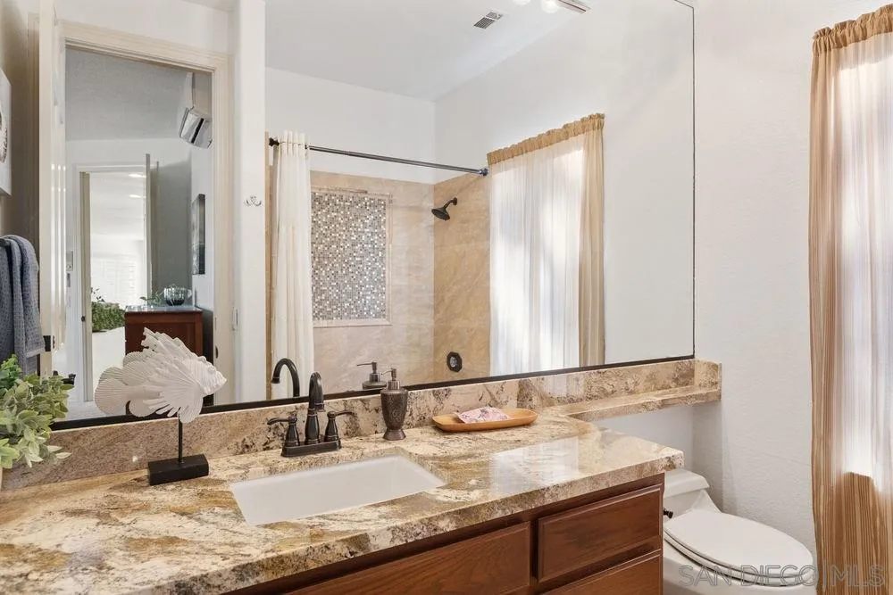 14331 Twisted Branch Road Poway, CA 92064 - Photo 21 of 25 a bathroom with a granite countertop sink a toilet and a mirror
