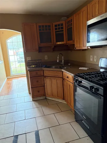 a kitchen with granite countertop a stove a sink and a microwave