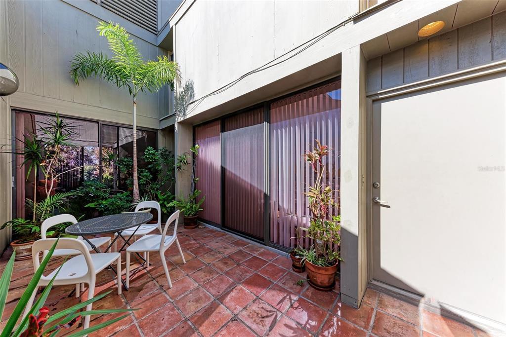 a view of a patio with table and chairs and potted plants