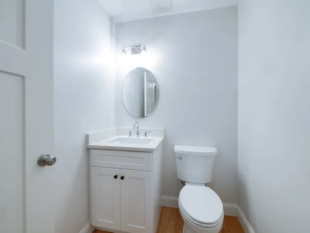 a bathroom with a toilet a sink and mirror
