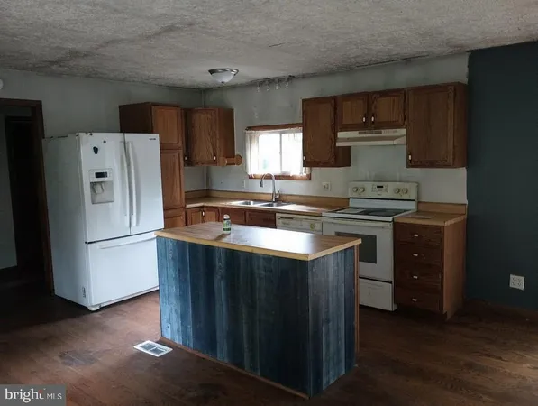 a kitchen with a sink a refrigerator a stove a microwave and cabinets