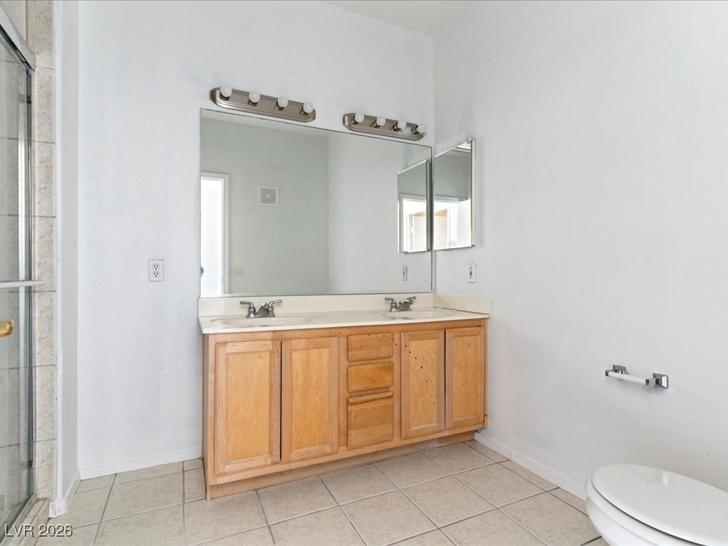 8725 West Flamingo Road, Unit 235 Las Vegas, NV 89147 - Photo 15 of 22 Bathroom with double vanity, a stall shower, and light tile patterned flooring