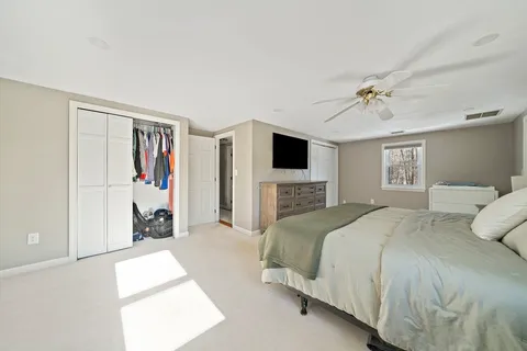 a spacious bedroom with a bed and a flat screen tv