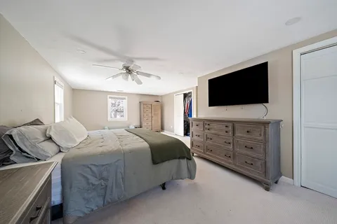 a spacious bedroom with a bed and a flat screen tv