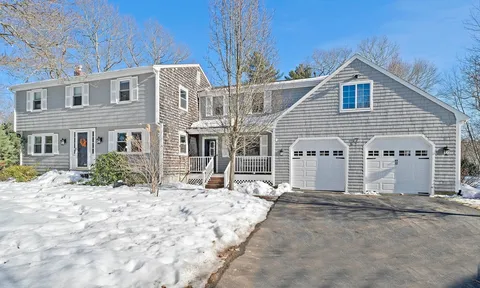 a view of a house with a yard covered in snow