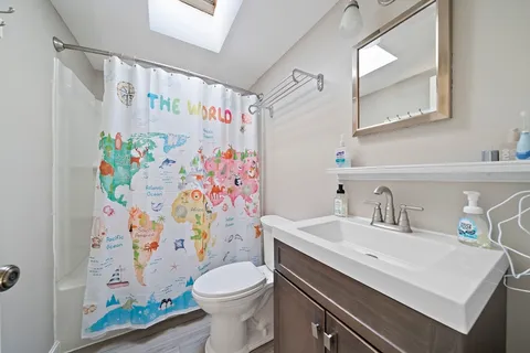 a bathroom with a sink a toilet and shower curtain