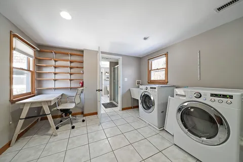 a view of a workspace with furniture and a window