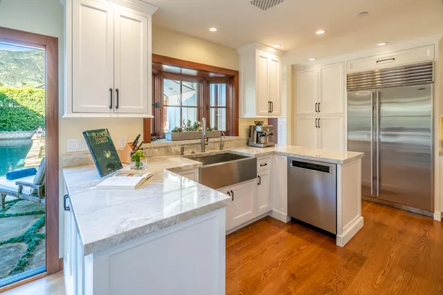 a kitchen with stainless steel appliances granite countertop a sink a stove and a refrigerator