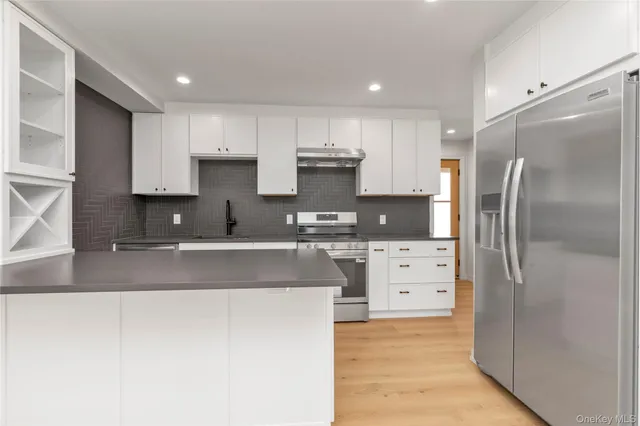 a kitchen with stainless steel appliances granite countertop a refrigerator and a stove