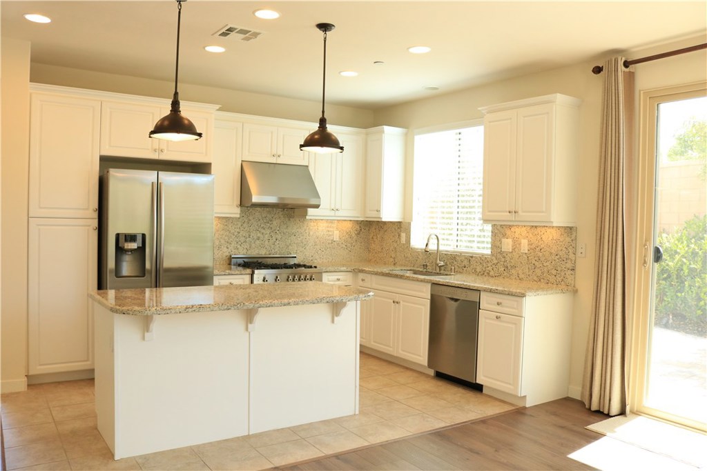 100 Desert Bloom Irvine, CA 92618 - Photo 4 of 15 a kitchen with stainless steel appliances granite countertop a stove a sink and a refrigerator
